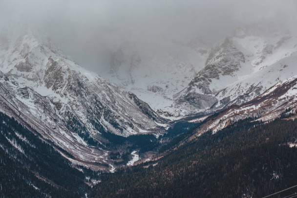 Ψηλά βουνά κάτω από χιόνι το χειμώνα. Μια σειρά από φωτογραφίες από τα βουνά του Καυκάσου, χιονοδρομικό κέντρο Dombay, Καρατσάι-Τσερκεσία - Φωτογραφία, εικόνα