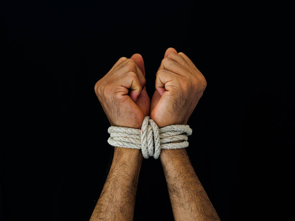 Las manos de los hombres estaban atadas con una cuerda. Violencia, aterrorizado, concepto del Día de los Derechos Humanos
. - Foto, imagen