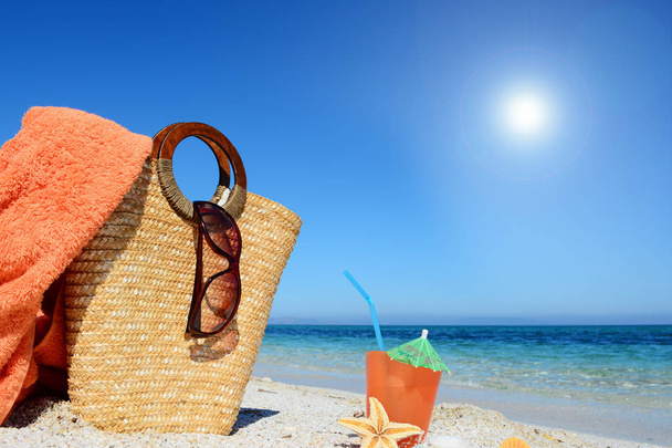Cocktail et sac de paille sous un soleil éclatant à la plage
 - Photo, image