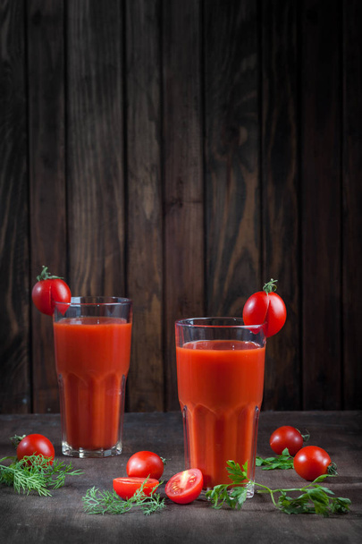 Tomato juice on dark wooden background vertical with blank space - Foto, afbeelding