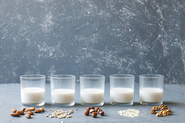 Vegan süt süt içinde gözlük kopya alanı ile ahşap arka plan üzerinde farklı türleri. - Fotoğraf, Görsel