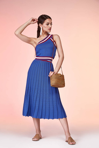 Pretty beautiful sexy elegance woman skin tan body fashion model glamor pose wear blue dress casual clothes for party summer collection makeup hair style brunette success accessory bag jewelry studio. - 写真・画像