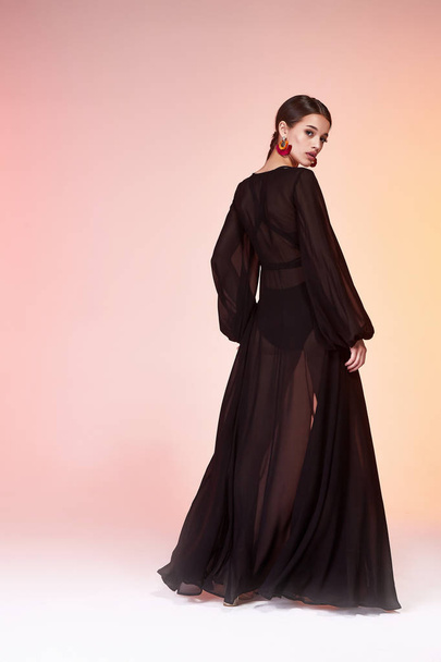 Pretty beautiful sexy elegance woman skin tan body fashion model glamor pose wear  long black silk dress clothes party summer collection makeup hair style brunette success accessory jewelry studio. - Valokuva, kuva