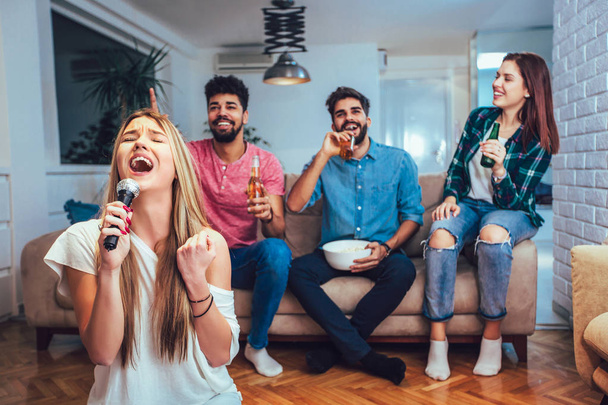 Group of friends playing karaoke at home. - Fotografie, Obrázek