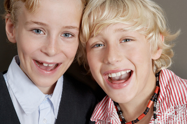 portret dwóch młodych braci, śmiejąc się z głowami razem z bliska. - Zdjęcie, obraz