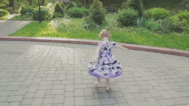 Family walks in the park with children. Sunny day. Green trees - Materiał filmowy, wideo