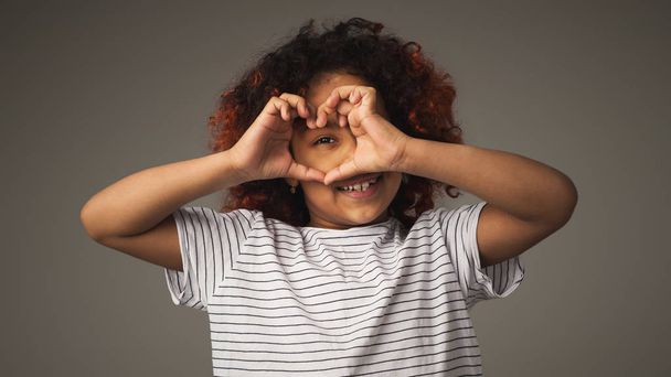 Happy černá holčička s prsty do tvaru srdce, Studiový portrét - Fotografie, Obrázek