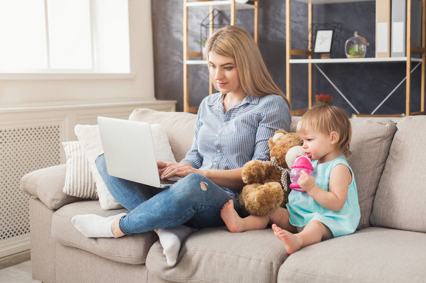Young mother working and spending time with baby - Photo, Image