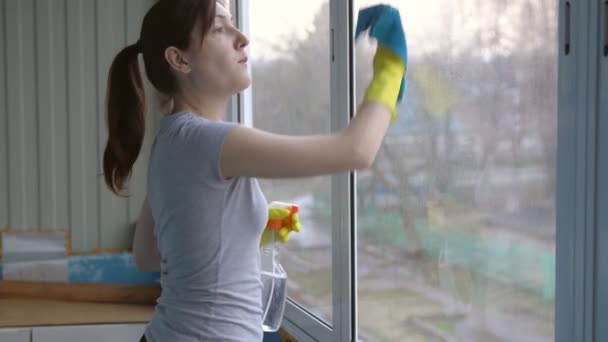 Hermosa mujer morena en guantes lava ventanas
 - Metraje, vídeo