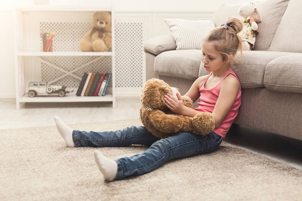 Klein meisje haar teddy bear knuffelen op verdieping - Foto, afbeelding