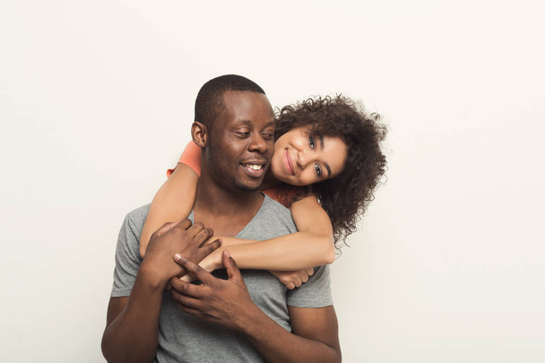 Black man piggybacking girlfriend at white studio - Photo, Image