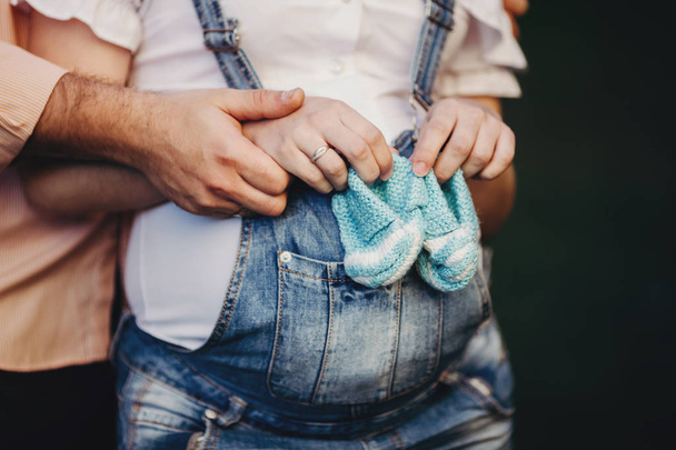 Elternhände mit Strickschuhen für ungeborenes Baby - Foto, Bild