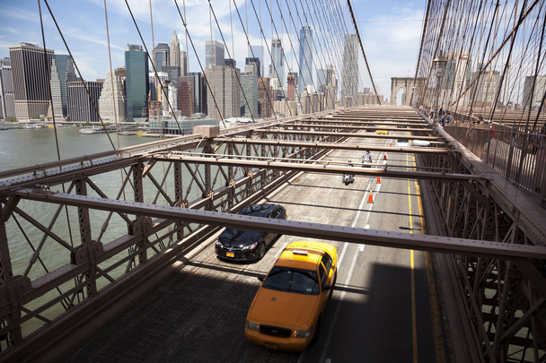 Manhattan, USA-9 June , 2017: Crossing the Brooklyn bridge towards manhattanon a sunny day - Photo, Image