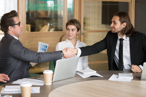 Un homme d'affaires serre la main d'un nouveau collègue lors d'une réunion d'équipe
 - Photo, image