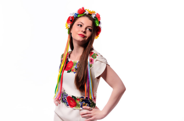 Meisje in de Oekraïense nationale klederdracht holding haar chaplet bloem - Foto, afbeelding