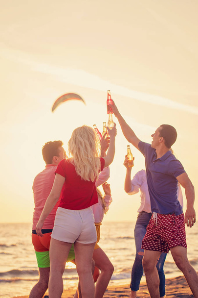 grupo de jóvenes felices con bebidas en la playa en el hermoso atardecer de verano
 - Foto, imagen