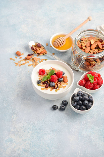 Zelfgemaakte muesli met yoghurt en verse bessen, gezond ontbijt concept, selectieve aandacht, ruimte kopiëren. - Foto, afbeelding