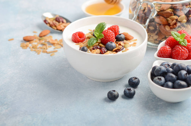 Granola casera con yogur y bayas frescas, concepto de desayuno saludable, enfoque selectivo, espacio para copiar
. - Foto, imagen