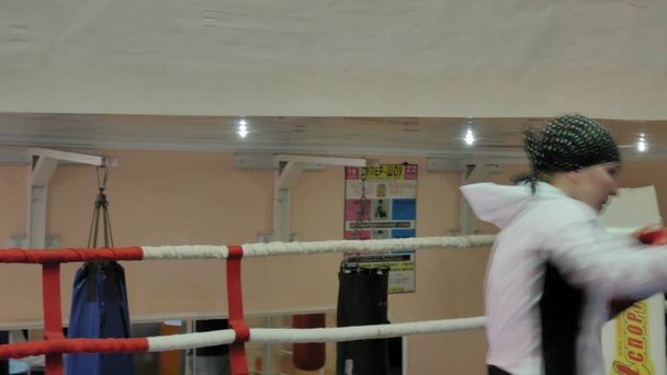 The trainer conducts a training battle with a female kickboxer in the ring - Fotó, kép