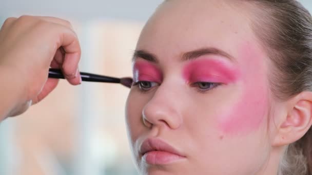 Unrecognizable visagist applying fluid foundation on young womans face using sponge. Professional makeup in salon. Nude makeup. - Footage, Video