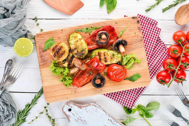 Grilled vegetables on a wooden board. On a wooden background. Top view. Copy space. - Фото, изображение