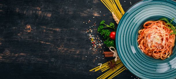 Linguine Pasta with tomatoes. On a wooden background. Italian cuisine. Top view. Copy space. - Photo, image