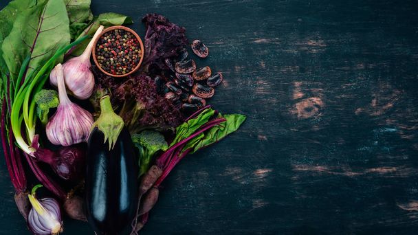 Purple food. Fresh vegetables and berries. On a wooden background. Top view. Copy space. - Foto, Imagen