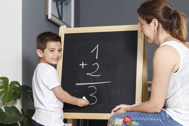 Матері вчить її син math вдома дошці  - Фото, зображення