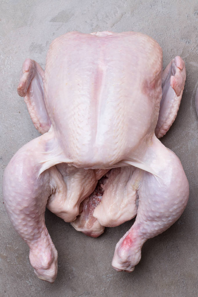 Целая биосырая, свежая курица, выделенная на сером фоне. Вид сверху
 - Фото, изображение