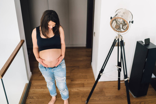 pregnancy details - portrait of healthy pregnant woman touching belly and looking at belly - Fotoğraf, Görsel