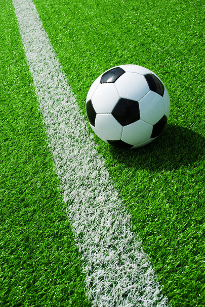 pelota de fútbol clásico, fútbol en negro y blanco sobre césped artificial verde con líneas
 - Foto, Imagen