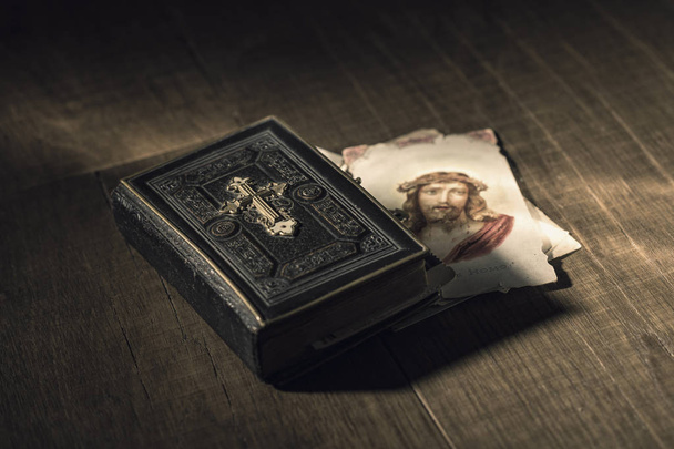 Sacred bible and Holy card with Jesus Christ image on a wooden desk, religion and faith concept - Photo, Image