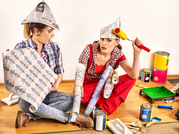 Reparar las mujeres del hogar sosteniendo la guía de color para el papel pintado
. - Foto, Imagen