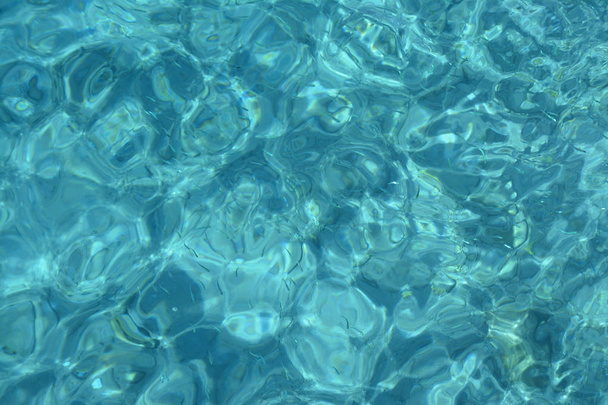 Θαλασσινό νερό βότσαλα και βράχια στην παραλία με καθαρό νερό μπλε διαφανές φόντο - Φωτογραφία, εικόνα