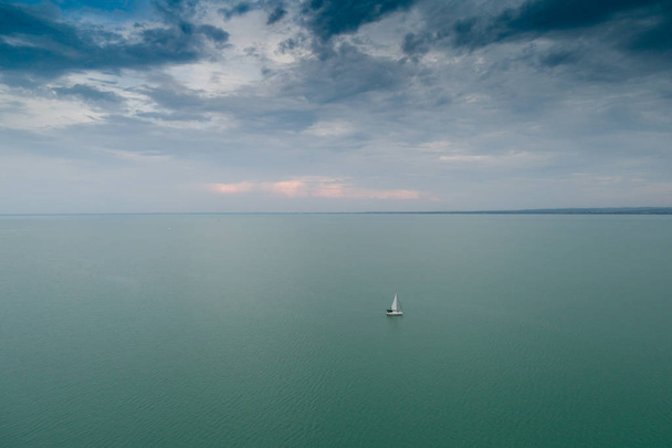 White sailing boat in Lake Balaton with cloud sky - Photo, Image