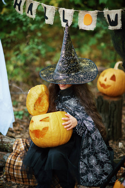 glückliches kleines Mädchen im Halloween-Kostüm mit Jack-Kürbissen - Foto, Bild