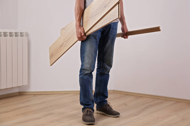 Well done. Man finished new laminate wooden flooring installing - Fotografie, Obrázek
