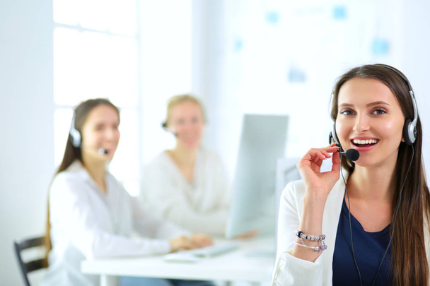 Usmívající se podnikatelka nebo operátorka telefonní linky se sluchátky a počítačem v kanceláři - Fotografie, Obrázek