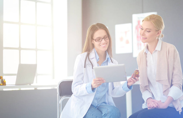 Doctor and patient discussing something while sitting at the table . Medicine and health care concept - Photo, Image