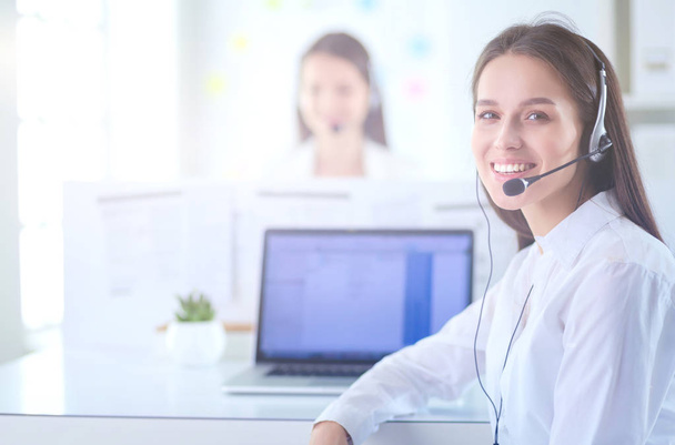 Smiling businesswoman or helpline operator with headset and computer at office - Foto, imagen