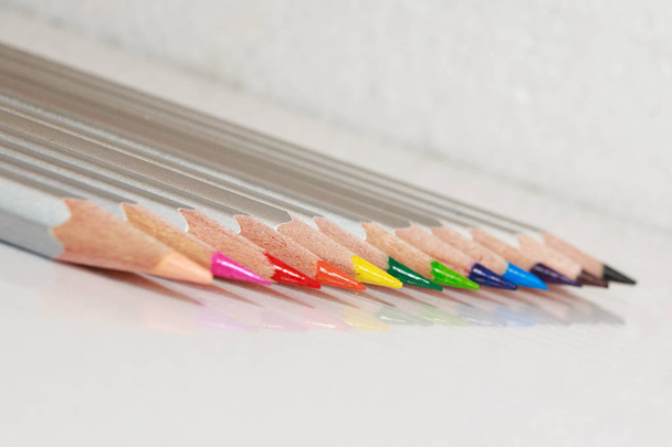 Lápices de color se encuentran en una línea sobre fondo blanco, espacio de copia
 - Foto, imagen
