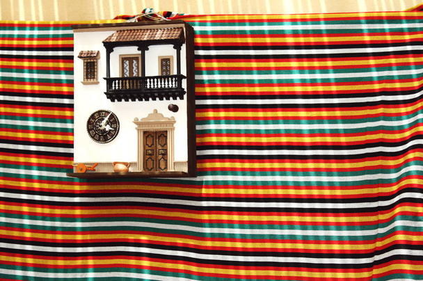 Imagen colorida con una fachada de una casa tradicional en miniatura colgada en la pared con un paño debajo
 - Foto, Imagen