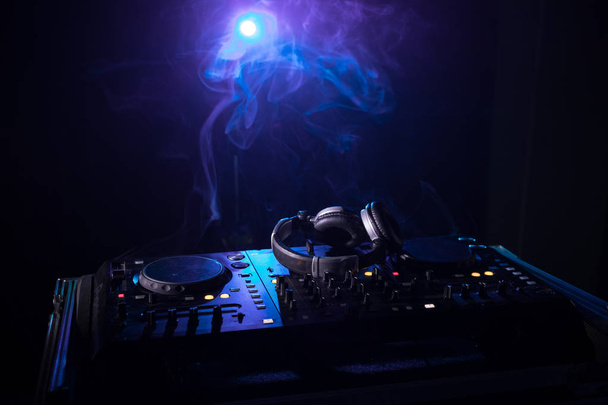DJ Spinning, Mixing, and Scratching in a Night Club, Manos de dj ajustar varios controles de pista en la cubierta de dj, luces estroboscópicas y niebla, o Dj mezcla la pista en el club nocturno en la fiesta. Enfoque selectivo
 - Foto, Imagen
