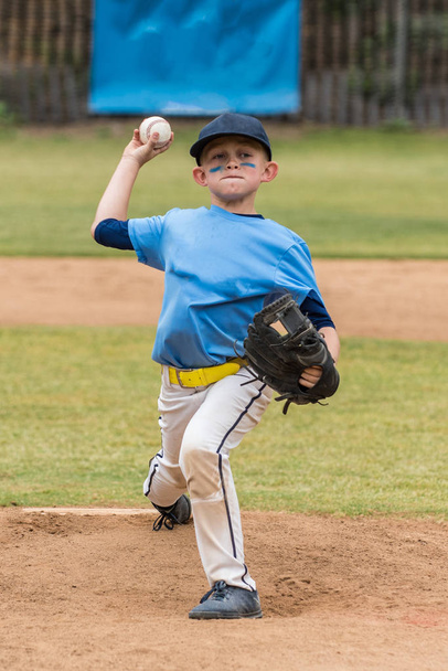 Dzban pokazuje twarz gry, jak mu wiatr się pokazać boisko podczas gry baseball. - Zdjęcie, obraz