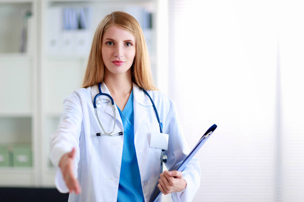 Portrait of woman doctor with folder at hospital corridor - Foto, Bild