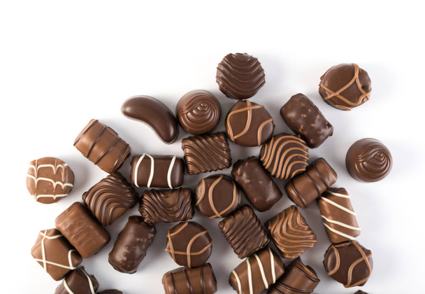 Kaunis Creative Chocolate Sweets eristetty valkoisella taustalla. Hajallaan suklaata Top View ja tasainen Lay
 - Valokuva, kuva