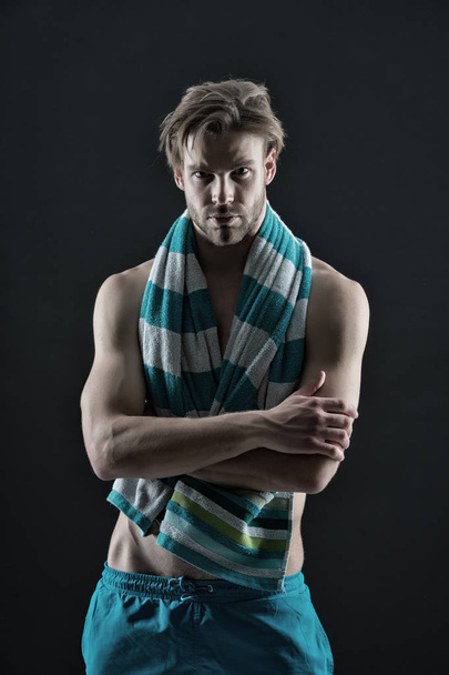Man with towel on neck after training. Sexy sportsman with muscular chest and belly. Fitness athlete with fit torso in shorts. Sport and wellness. Hygiene, health and bodycare concept, vintage filter - 写真・画像