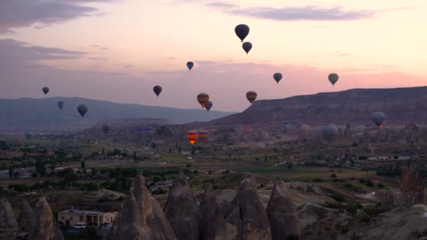 Siluetas Muchos globos aerostáticos volando sobre valles en Goreme, Turquía. Turistas de todo el mundo vienen a Capadocia para hacer un viaje en globos aerostáticos
. - Imágenes, Vídeo