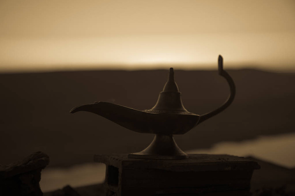 Антикварні кустарних Аладдін арабській ночі genie стиль нафту лампу з м'яке світло білий дим. Під час заходу сонця фону. Лампа бажань. Вибірковий фокус - Фото, зображення