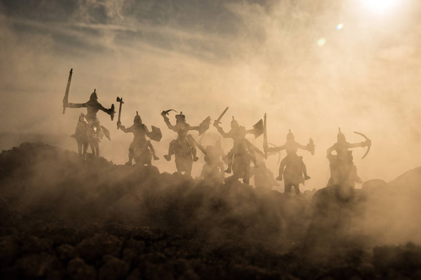 Średniowieczne bitwy sceny z kawalerii i piechoty. Sylwetki postaci jako oddzielne obiekty, walka pomiędzy wojowników na tle mglisty zachód słońca. Selektywny fokus - Zdjęcie, obraz